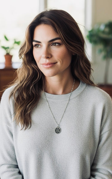Woman wearing a light gray sweater with a silver Star of David necklace